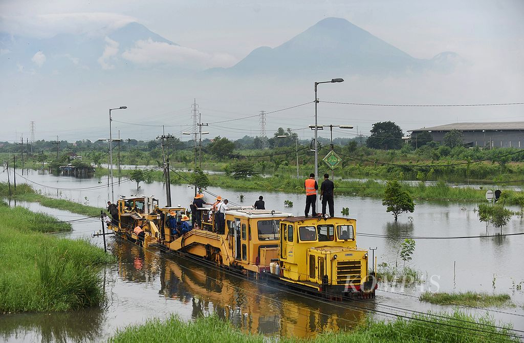 Rangkaian kereta api profile <i>ballast regulator</i> memeriksa jalur kereta api yang terendam banjir di Jalan Raya Porong di Sidoarjo, Jawa Timur, Sabtu (13/2/2016). Banjir setinggi hampir mencapai 1 meter masih memutus jalur kereta api dan Jalan Raya Porong.