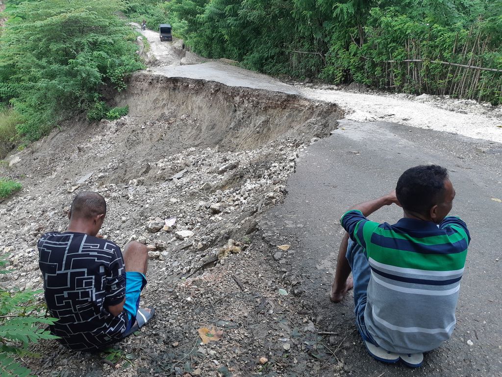 Two transport car drivers waited for passengers across from the Kiupakas landslide site, Oemasi Village, Nekamese District, Kupang Regency, East Nusa Tenggara on Sunday (12/2/2023). This section of the road is no longer passable by four-wheeled vehicles.