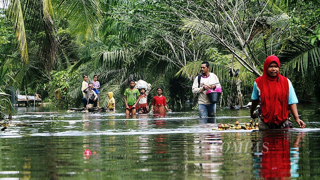 Warga menerobos banjir di Desa Cot U Sibak, Kecamatan Lhoksukon, Kabupaten Aceh Utara, Provinsi Aceh, Kamis (7/12). Banjir yang melanda 23 kecamatan di Aceh Utara dipicu hujan deras dan rusaknya tanggul penahan air di beberapa sungai. Sebanyak 15.000 warga harus mengungsi karena rumah mereka tergenang.