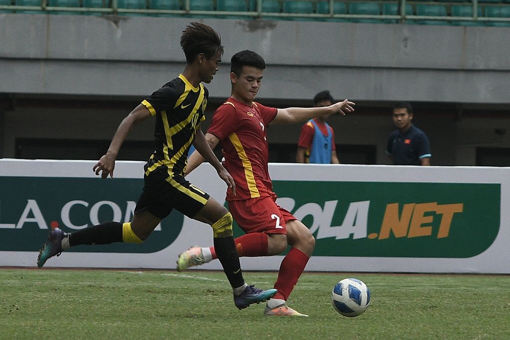 Pesepakbola Timnas Vietnam U-19 Ha Chau (kanan) berebut bola dengan pesepakbola Timnas Malaysia U-19 Adam Farhan (kiri) dalam laga semifinal Piala AFF U-19 2022 di Stadion Patriot Chandrabhaga, Bekasi, Jawa Barat, Jumat (13/7/2022). 