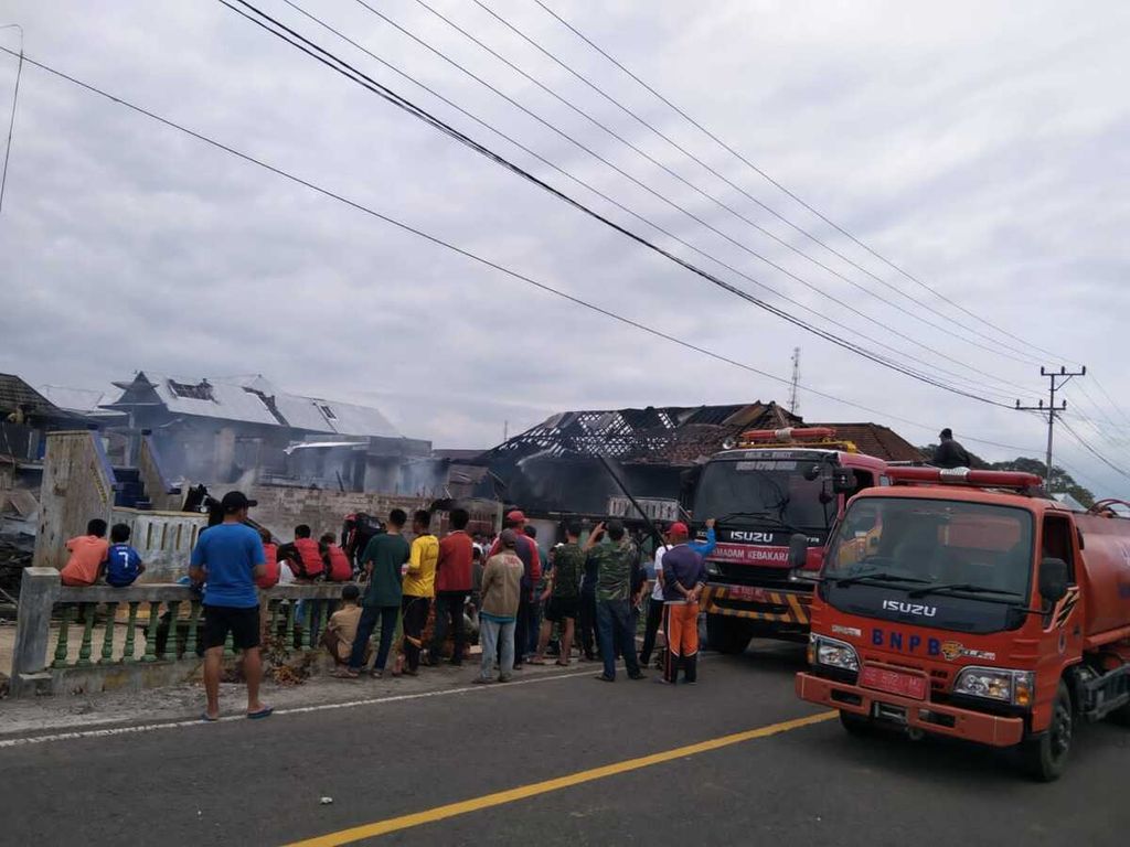 Mobil pemadam kebakaran berupaya memadamkan tiga rumah panggung milik warga di Pekon Kenali, Kecamatan Belalau, Kabupaten Lampung Barat, Lampung, yang terbakar pada Jumat (22/7/2022). 