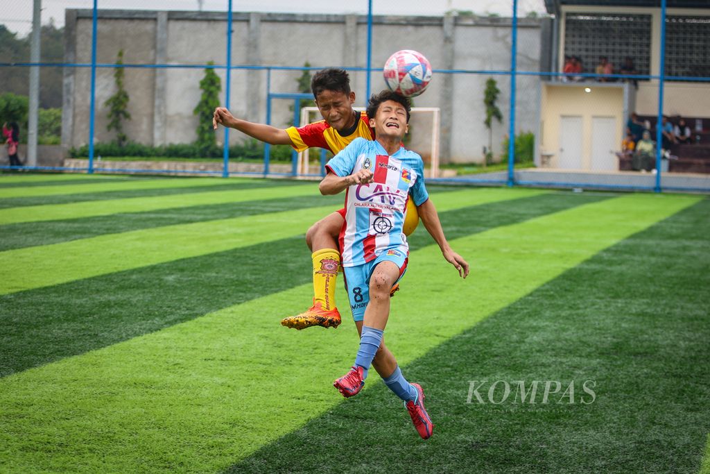Pemain Salfas Soccer, Fahmi Trisatya (kiri), berebut menyundul bola dengan pemain Remci FC, Abdul Karim Alfaridzky, dalam laga babak <i>playoff</i> Liga Kompas Kacang Garuda U-14 di Dewantara Sport Center, Tangerang Selatan, Banten, Minggu (12/11/2023).  
