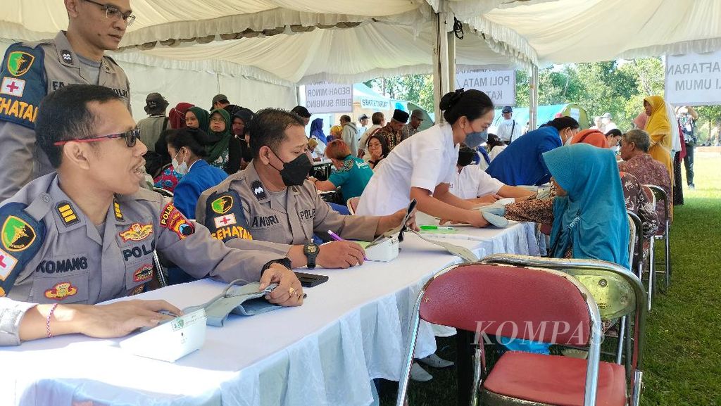 Polisi dan perawat bekerja sama membantu pemeriksaan kesehatan di acara pengobatan massal yang digelar Walubi, Selasa (30/5/2023).