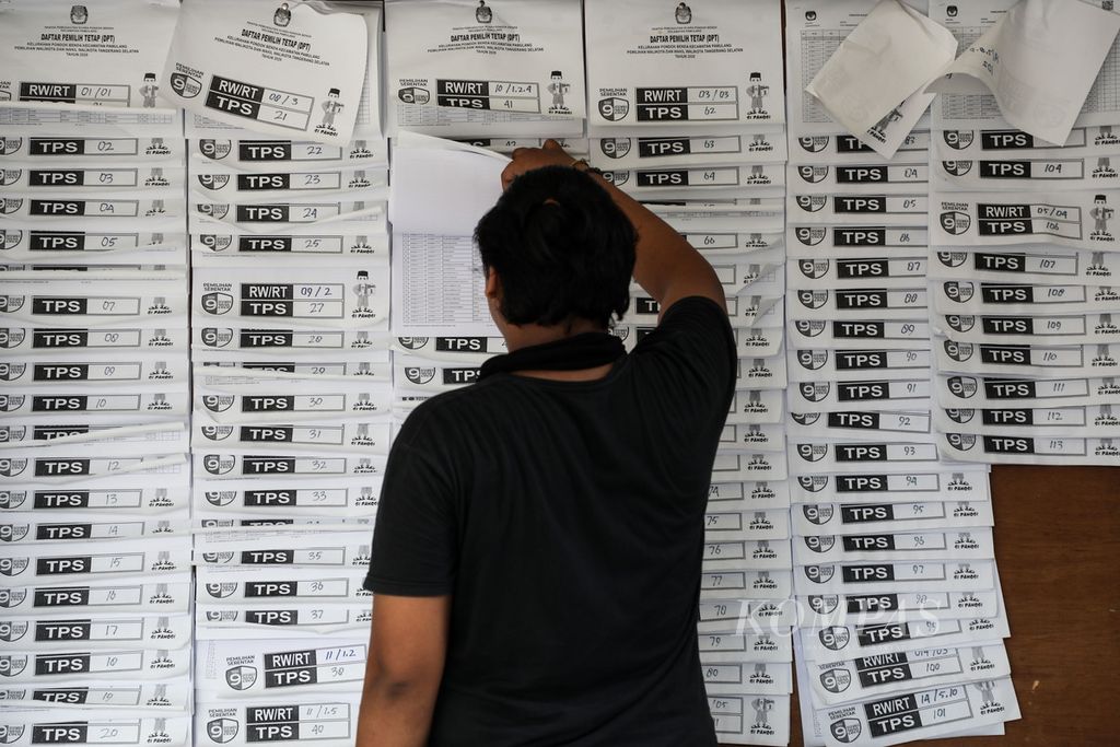 Warga memeriksa nama-nama dalam daftar pemilih tetap untuk pemilihan wali kota dan wakil wali kota Tangerang Selatan yang dipajang di Kantor Kelurahan Pondok Benda, Pamulang, Tangerang Selatan, Minggu (29/11/2020). 