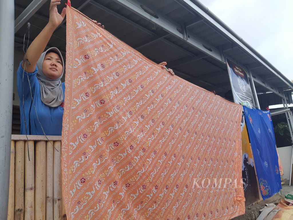 Seorang pelajar SMK menjemur kain batik besurek di Kampung Batik Betungan, Kota Bengkulu, Jumat (17/11/2023). Di kampung batik tersebut, ada belasan rumah tangga yang membuka usaha pembuatan batik tulis.