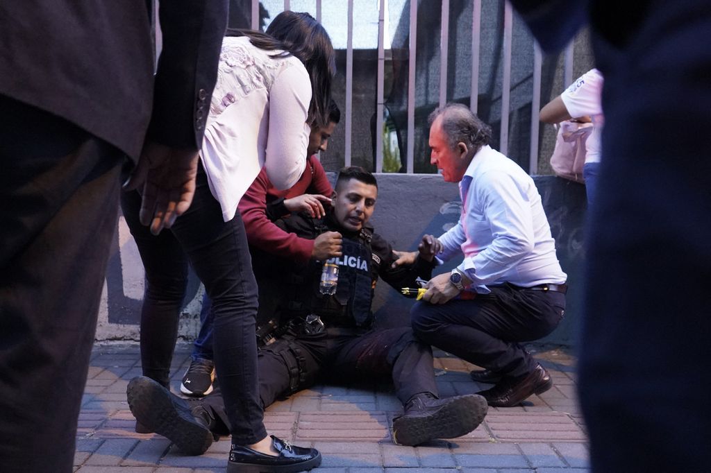 Warga membantu polisi yang terluka setelah terjadi penembakan dalam kampanye calon presiden Ekuador, Fernando Villavicencio, di Quito, Rabu (9/8/2023). 