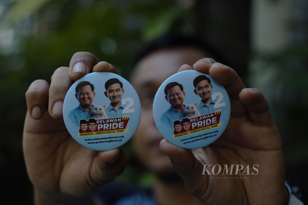 Anggota sukarelawan memperlihatkan pin bergambar calon presiden-calon wakil presiden Prabowo Subianto-Gibran Rakabuming Raka menggunakan bantuan kecerdasan buatan.