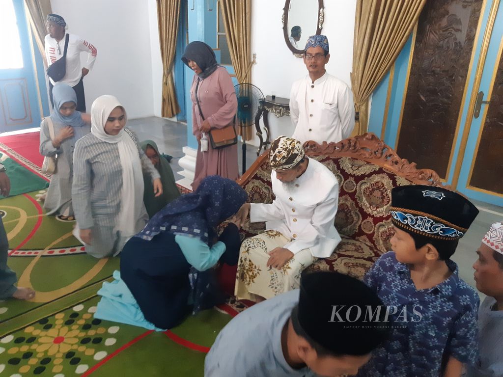 Warga mengantre untuk bersalaman dengan Sultan Kanoman XII Raja Muhammad Emirudin (duduk di kursi) saat halalbihalal atau <i>pisowanan ageng</i> di Pendopo Jinem, Keraton Kanoman, Kota Cirebon, Jawa Barat, Senin (15/4/2024). Kegiatan itu menjadi ajang silaturahmi keluarga besar Kesultanan Kanoman dengan masyarakat setelah Idul Fitri 1445 Hijriah.