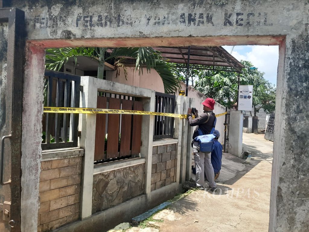 Dua jurnalis mengabadikan proses identifikasi oleh polisi di rumah sewa korban bunuh diri keluarga di Dusun Borobugis, Desa Saptorenggo, Kecamatan Pakis, Kabupaten Malang, Jawa Timur, Selasa (12/12/2023).