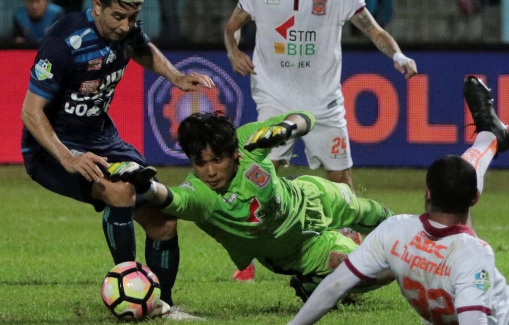 Gelandang Arema FC Esteban Vizcarra (kiri) berusaha merebut bola dari kipr Borneo FC Muhammad Ridho (tengah)  dalam lanjutan Gojek Traveloka Liga Satu, Minggu (30/7) di Stadion Kanjuruhan Malang, Jawa Timur. Pada babak pertama kedudukan imbang 0-0.