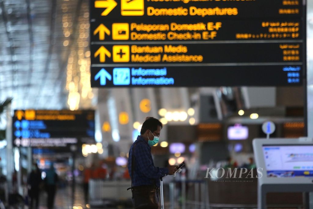 Calon penumpang melihat jadwal tiketnya saat tiba di Terminal 3 Bandara Soekarno-Hatta, Tangerang, Senin (2/3/2020). 
