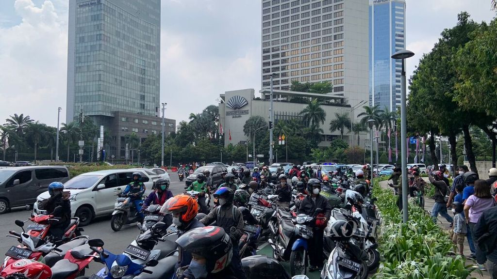 Puluhan pengguna Jalan MH Thamrin, Jakarta Pusat, memarkirkan kendaraannya di tepi jalan untuk bisa melihat para pebalap MotoGP di dalam halaman Hotel Kempinski, Rabu (16/3/2022) siang.