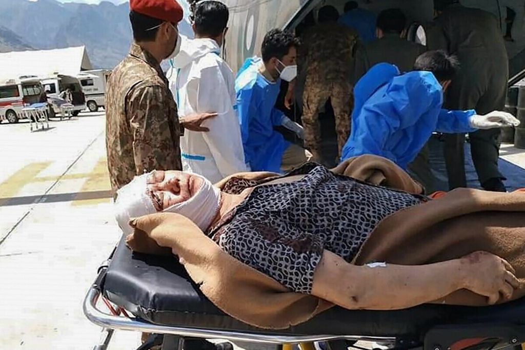 Tentara Pakistan memindahkan seorang warga China yang terluka setelah sebuah bus jatuh ke jurang menyusul ledakan yang menewaskan 13 orang di sebuah rumah sakit di Gilgit, 14 Juli 2021. 