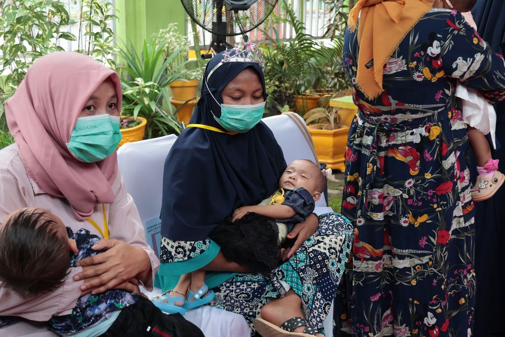 Dua ibu membawa putra mereka ke Kantor Kelurahan Kayubulan, Kabupaten Gorontalo, Provinsi Gorontalo, Jumat (14/4/2023). 