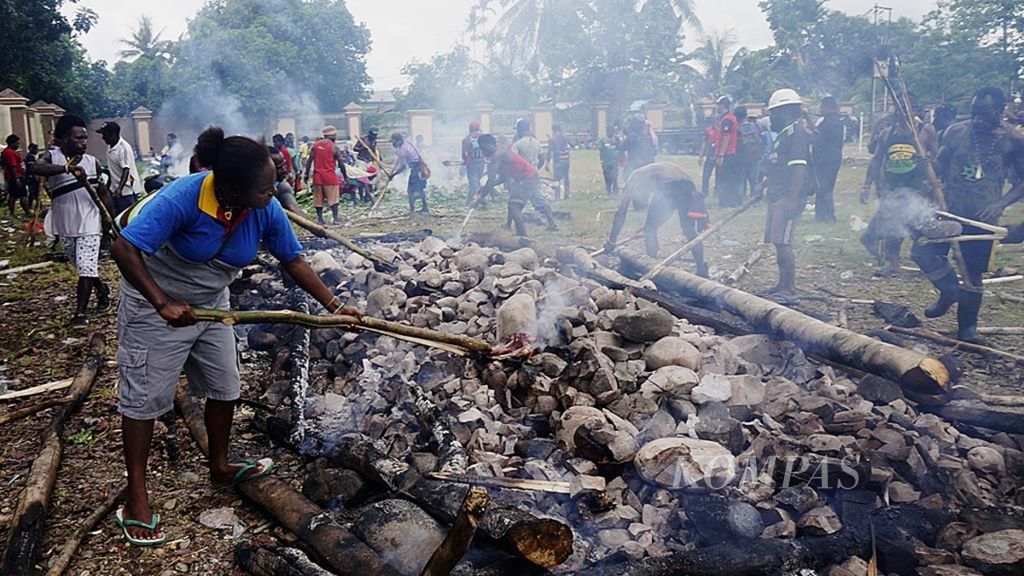 Ratusan pengungsi melakukan upacara bakar batu sebagai bentuk kekerabatan sekaligus penerimaan pemerintah kepada warga yang datang, beberapa waktu lalu, di halaman gedung posko pengungsian, Timika, Papua. Konflik bersenjata yang terjadi di empat kampung di Distrik Tembagapura, Timika, membuat warga harus mengungsi dan meninggalkan kampung mereka.
