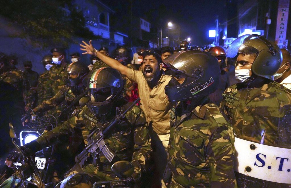 Seorang pengunjuk rasa meneriakkan slogan-slogan yang mengecam pemerintah dalam mengatasi krisis ekonomi dalam aksi protes di luar kediaman pribadi presiden Sri Lanka. Unjuk rasa kemudian diwarnai kericuhan setelah polisi menembakkan gas air mata dan meriam air untuk membubarkan massa.