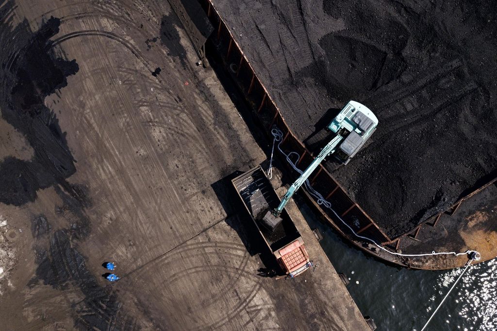 Ekskavator memindahkan batubara yang didatangkan dari Kalimantan dari tongkang ke atas truk di Pelabuhan KCN Marunda, Jakarta Utara, Rabu (5/1/2022). 