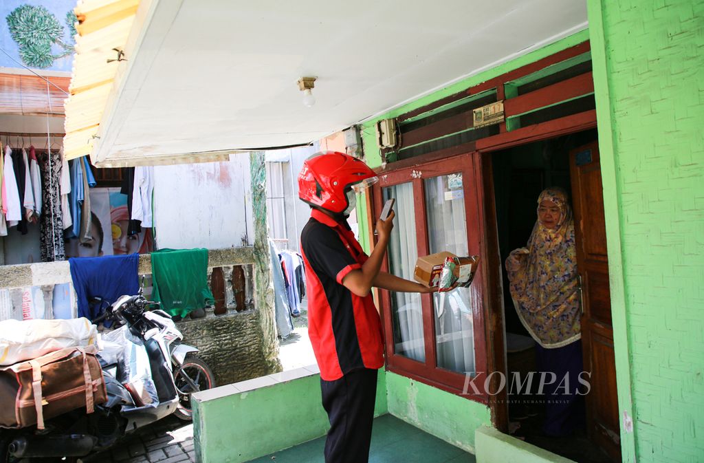 Kurir paket SiCepat, Andika, mengantarkan paket ke pelanggan di kawasan Parung Serab, Ciledug, Kota Tangerang, Banten, Rabu (6/4/2022). Setiap hari Andika mengantarkan sekitar 150 paket di kawasan tersebut.