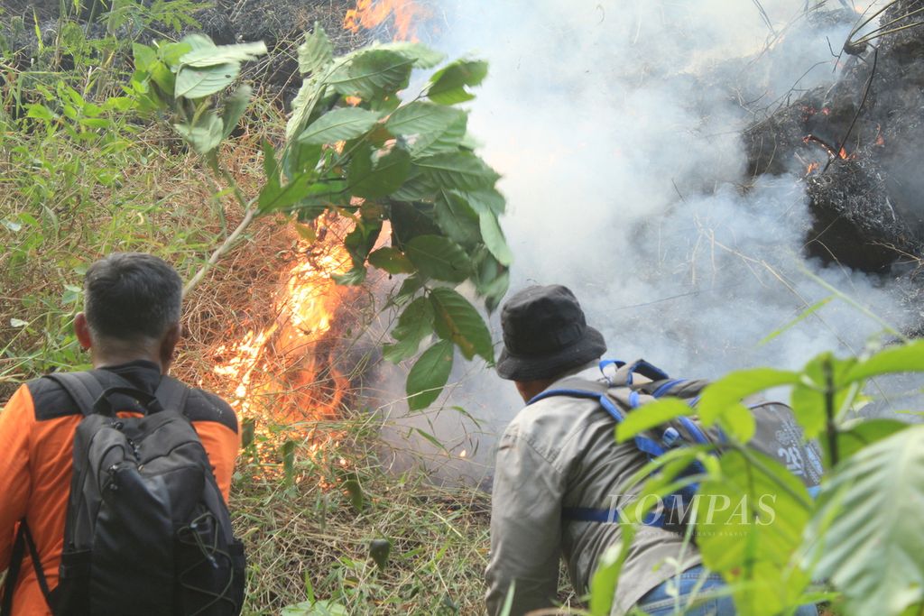 Petugas berupaya memadamkan api di Blok Karangsanggar, Desa Pasawahan, Kecamatan Pasawahan, Kabupaten Kuningan, Jawa Barat, Minggu (27/8/2023) sore. 