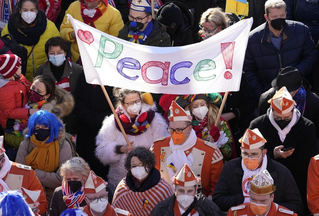 Carnival revelers show signs for peace in Cologne, Germany, during a peace march of tens of thousands against the war in Ukraine on Shrove Monday, Feb. 28, 2022. The traditional carnival Rose Monday Parade in Cologne was cancelled due to Russia's war in Ukraine. Instead of the parade, the political carnival floats were placed in the city followed by a peace protest of revelers.