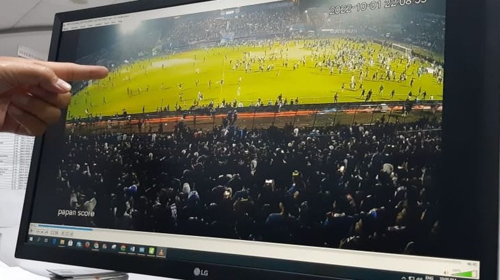 Seorang warga menunjukkan foto penembakan gas air mata yang mengarah ke tribune penonton di sisi selatan Stadion Kanjuruhan, Malang, Jawa Timur, Rabu (9/11/2022). Penembakan ini memicu kepanikan sehingga sejumlah penonton berdesak-desakan keluar, sementara yang lain lemas karena paparan gas air mata.