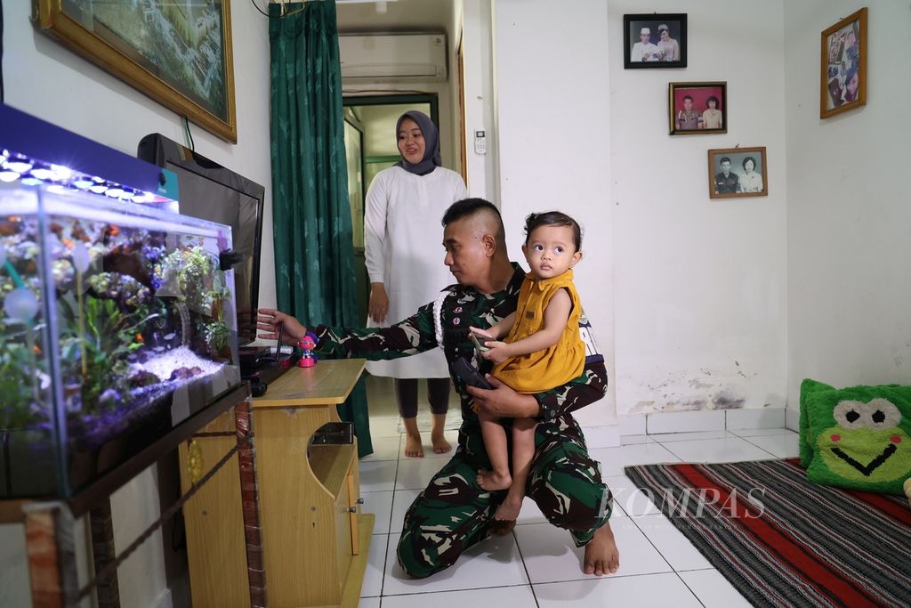 Second Corporal Haris Aditya holds his daughter in the flat of Indonesian Army soldiers in Cililitan, East Jakarta, Tuesday (6/9/2022). There are five towers in this TNI AD soldier's flat complex.