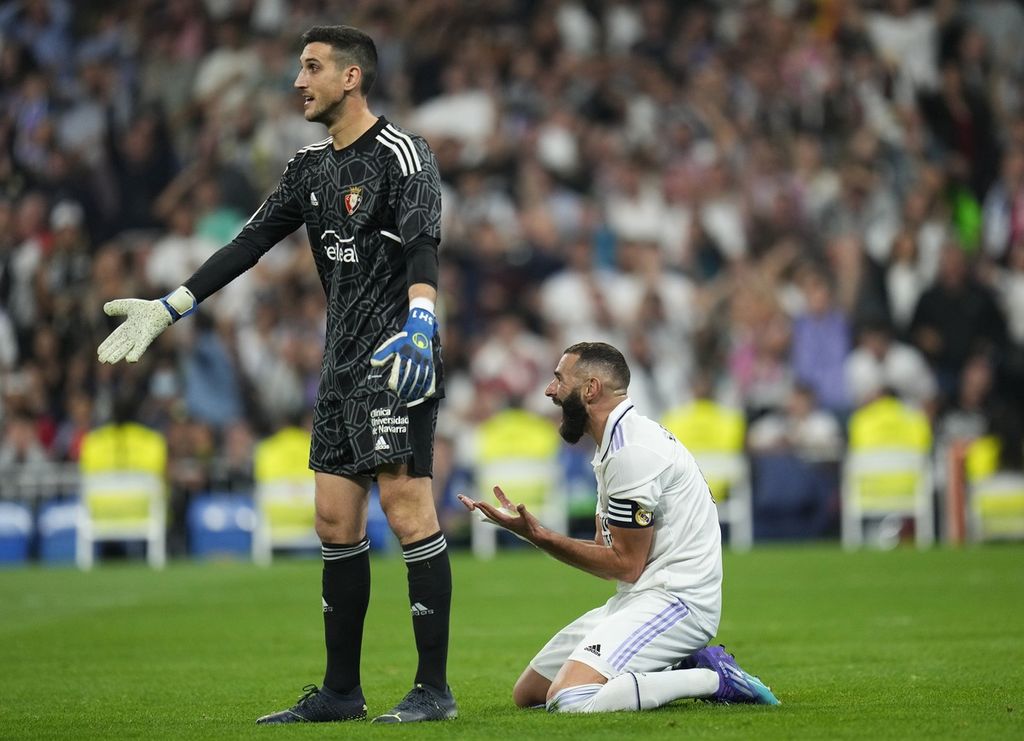 Ekspresi pemain Real Madrid Karim Benzema (kanan) dan kiper Osasuna Sergio Herrera saat Osasuna dijatuhi hukuman penalti, pada laga Liga Spanyol, di Stadion Santiago Bernabeu, Madrid, Minggu (2/10/2022). Laga itu berakhir imbang 1-1. 