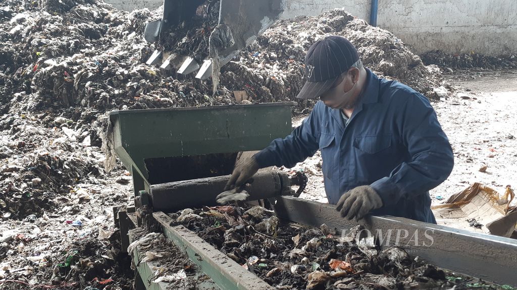Seorang pekerja dari PT Bhakti Bumi memilah ulang residu sampah rumah tangga yang akan diolah menjadi bahan bakar jumputan padat atau <i>refused derived fuel</i> (RDF) di Tempat Pemrosesan Akhir Jabon, Sidoarjo, Jawa Timur, Jumat (16/9/2022). 