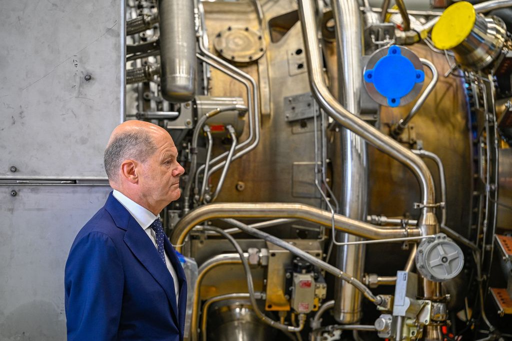 Kanselir Jerman Olaf Scholz berdiri di dekat turbin Nord Stream 1  pada kunjungan 3 Agustus 2022 di pembangkit Siemens Energy di Muelheim an der Ruhr, Jerman, 3 Agustus 2022. (Photo by SASCHA SCHUERMANN / AFP)