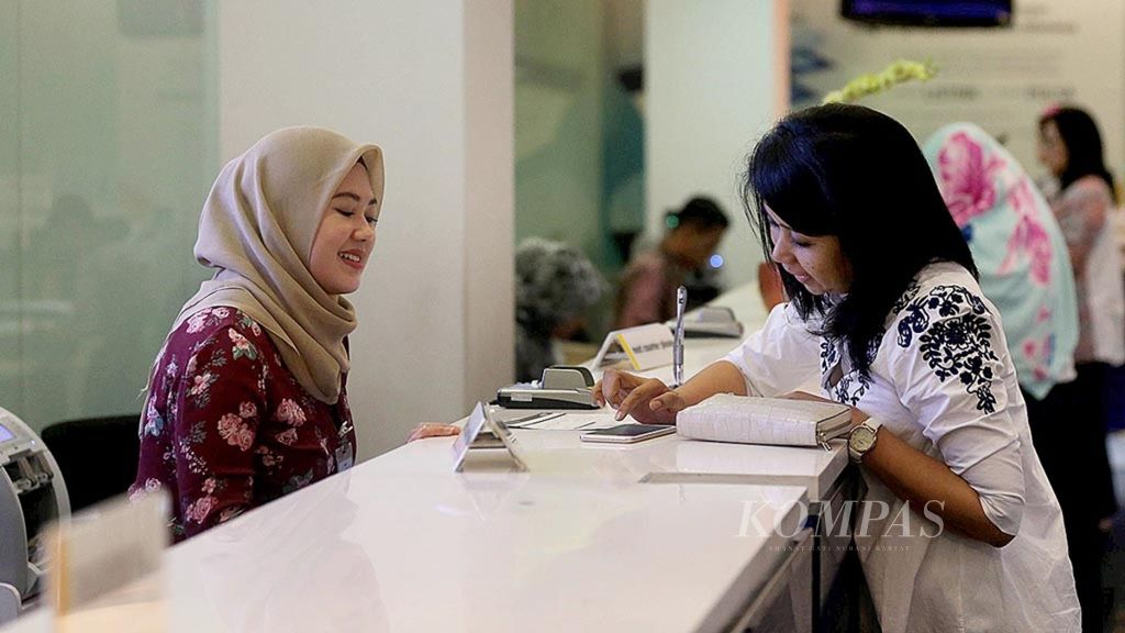 Petugas <i>teller </i>Bank Mandiri melayani nasabah di kantor cabang Plaza Mandiri, Jakarta, Jumat (11/8/2017). 