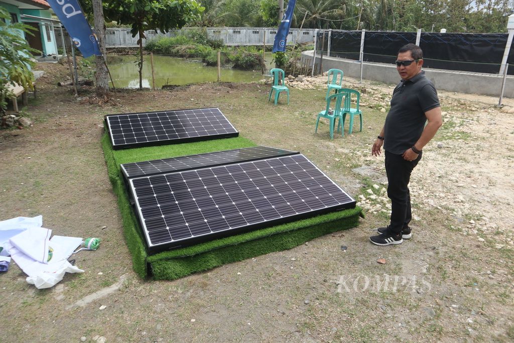 Kepala Dinas Kelautan dan Perikanan Jabar Hermansyah menunjukkan panel surya yang terhubung dengan kolam udang di UPTD Perikanan Air Payau dan Laut Wilayah Selatan (PAPLWS), Kabupaten Pangandaran, Minggu (28/8/2022). Panel surya berkapasitas 2 kilowatt peak (kWp) itu dapat menghemat energi 2.094 kilowatt hour (kWh) per tahun.
