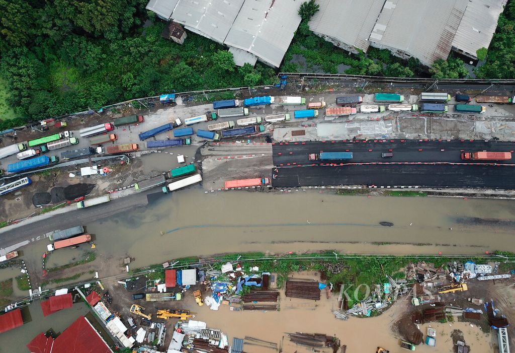 Truk-truk menunggu selama hampir dua hari agar dapat melintasi banjir di jalur pantura, Kaligawe, Kota Semarang, Jawa Tengah, Jumat (15/3/2024). 