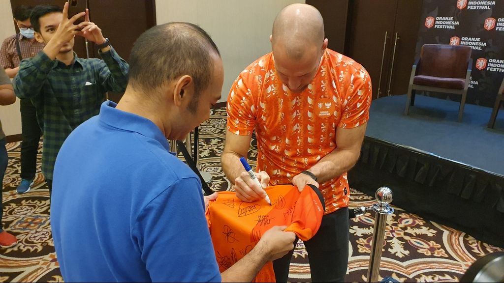 Mantan pemain timnas Belanda, Ron Vlaar, memberikan tanda tangan di jersei milik suporter Belanda seusai jumpa pers soal Oranje Indonesia Festival di Jakarta, Kamis (24/11/2022). 