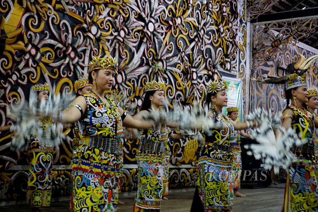 Para penari perempuan menari dengan anggun di hadapan penonton di lamin adat pamung tawai, rumah adat suku dayak kenyah di Kelurahan Pampang, Kecamatan Samarinda Utara, Samarinda, Kalimantan Timur, Minggu (29/10/2019).