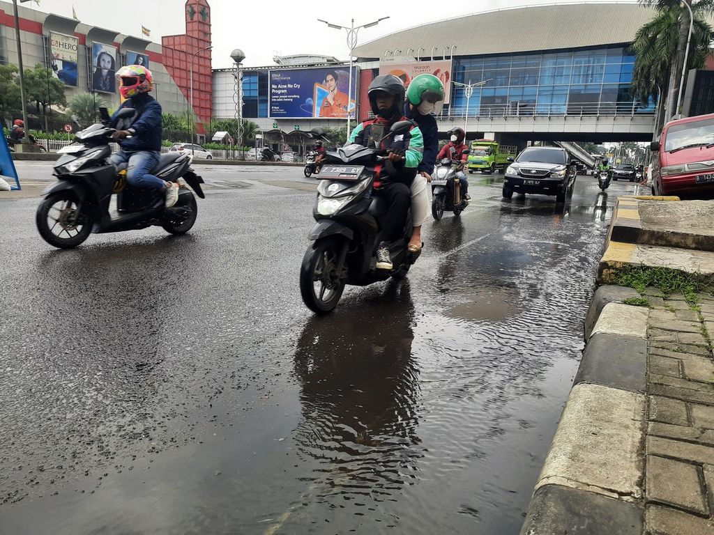 Para pengguna jalan mengurangi laju kendaraan akibat air menggenang di depan Mal Pondok Indah 2, Jakarta, Jumat (17/3/2023).
