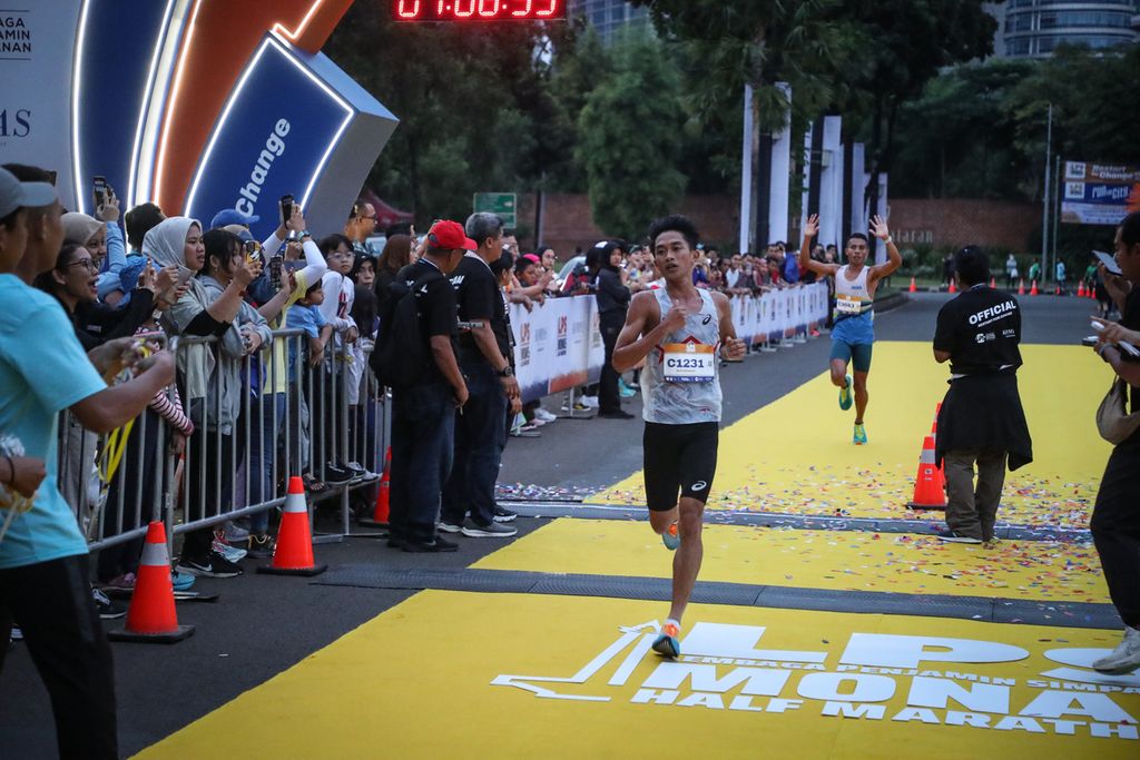 Pelari asal Indonesia, Robi Syianturi (depan), sampai di garis finis dalam ajang LPS Monas Half Marathon di Istora Senayan, Jakarta, Minggu (2/7/2023). 