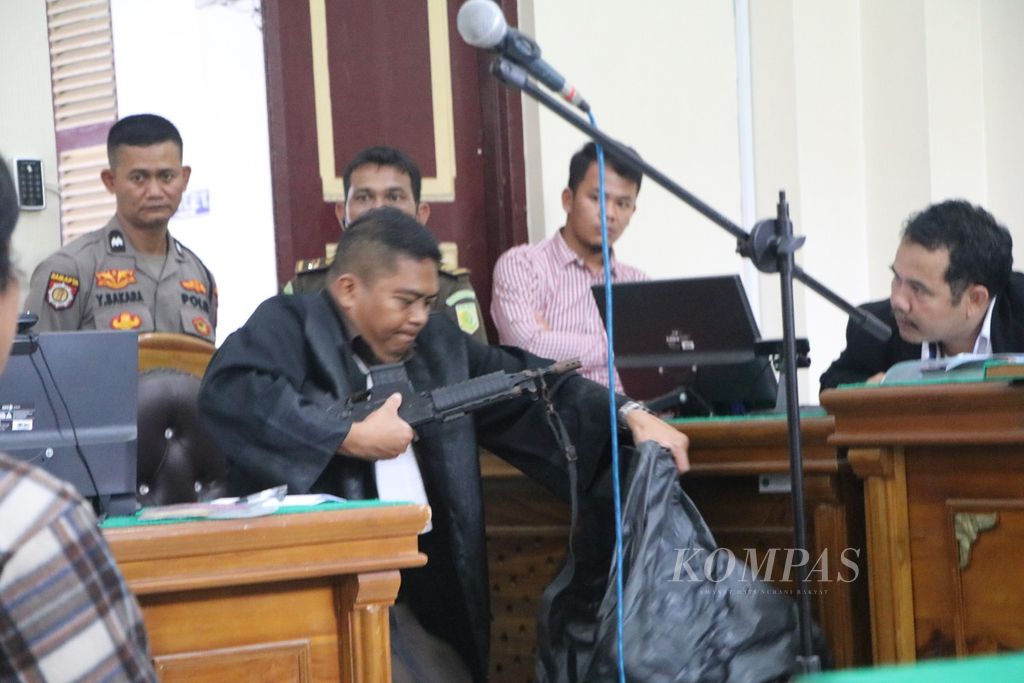 Jaksa penuntut umum menunjukkan senjata laras panjang terdakwa Ajun Komisaris Besar Achiruddin Hasibuan untuk mengancam korban penganiayaan Ken Admiral, di Pengadilan Negeri Medan, Sumatera Utara, Senin (17/7/2023).