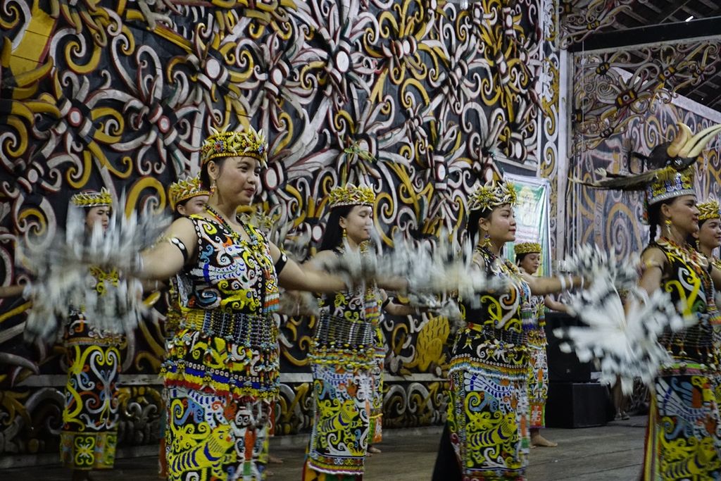 Para penari perempuan menari dengan anggun di hadapan penonton di lamin adat pamung tawai, rumah adat suku dayak kenyah di Kelurahan Pampang, Kecamatan Samarinda Utara, Samarinda, Kalimantan Timur, Minggu (29/10/2019).
