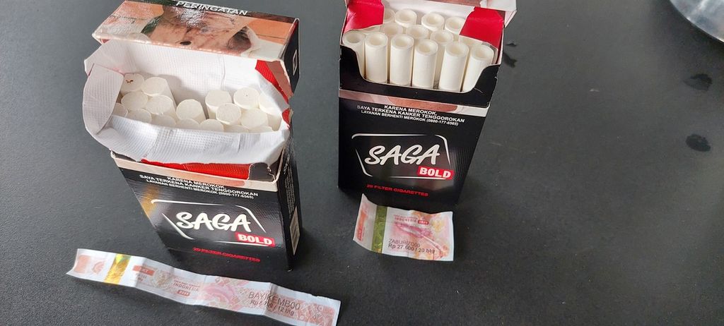 Produk rokok Saga Bold dengan dua jenis pita cukai yang berbeda. Produk yang kiri adalah produk dengan pita cukai kertas panjang SKT (sigaret kretek tangan) dan produk kanan adalah produk yang dilekati pita cukai kertas pendek SKM (sigaret kretek mesin).