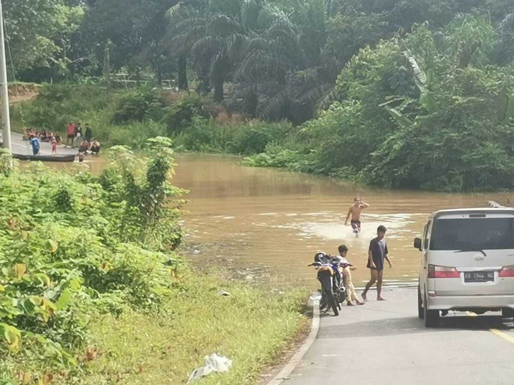 Banjir rendam Jalan Trans-Kalimantan yang menghubungkan Kalteng dengan Kalimantan Barat, pada Senin (10/10/2022). Banyak kendaraan harus berputar balik karena jalan putus.