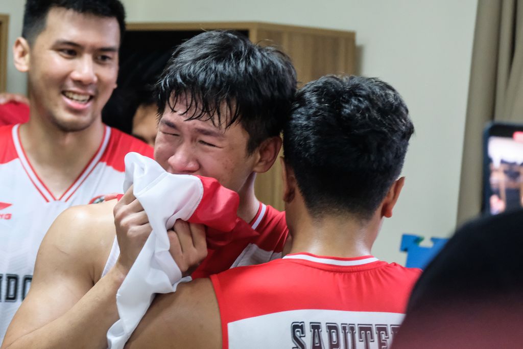 <i>Guard </i>timnas basket Indonesia, Abraham Damar Grahita, menangis seraya mencium "Sang Merah-Putih" setelah mengantar Indonesia juara SEA Games Vietnam 2021 di Thanh Tri Indoor Stadium, Hanoi,  Minggu (22/5/2022).