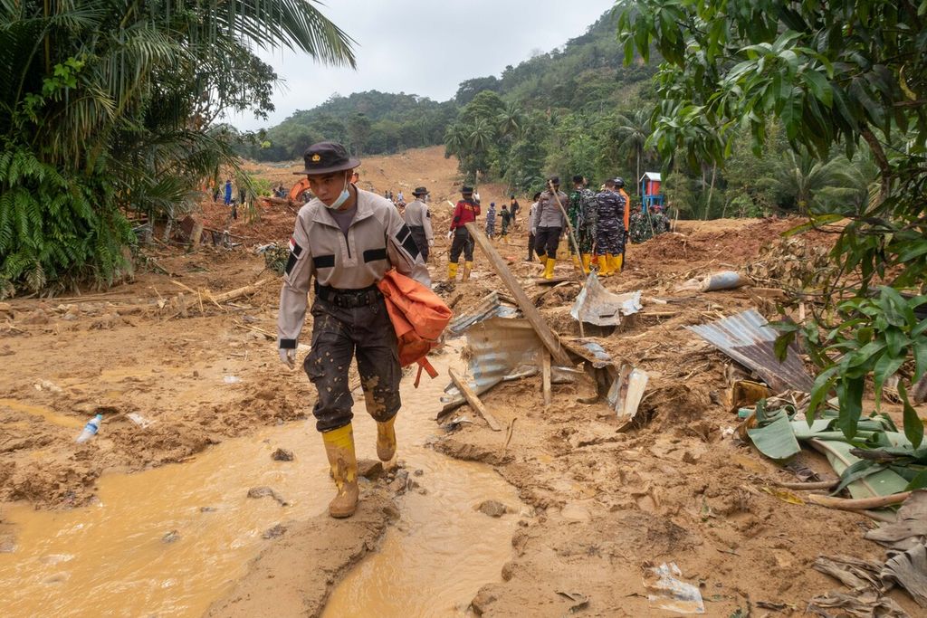 Seorang polisi anggota Satuan Tugas Tanggap Bencana Natuna melintas di lokasi bencana tanah longsor di Desa Pangkalan, Pulau Serasan, Natuna, Kepulauan Riau, Sabtu (11/3/2023).