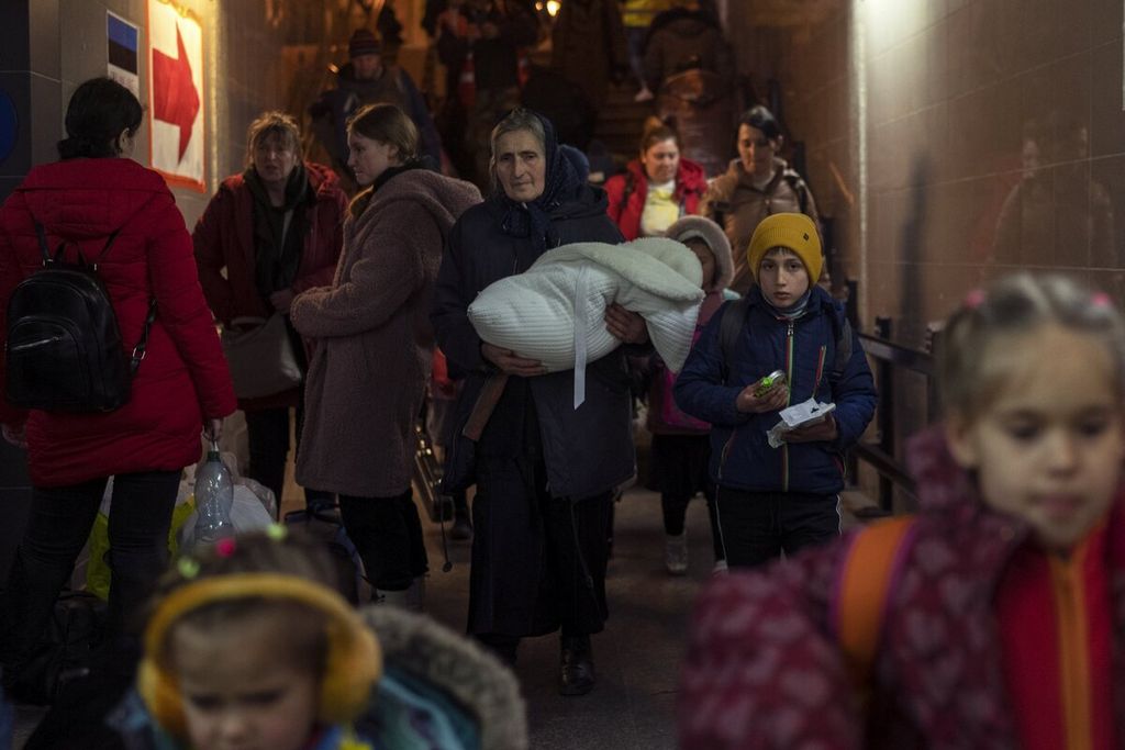Warga yang mengungsi karena perang di Ukraina meninggalkan stasiun kereta api Przemysl di Przemysl, Polandia, Selasa (15/3/2022). Upaya untuk membawa warga sipil ke tempat yang aman dan memberikan bantuan sedang berlangsung di wilayah Ukraina. 