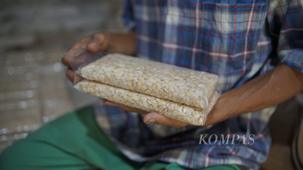 Jasuta (55) menunjukkan tempe yang dihasilkannya, saat ditemui di bengkel pembuatan tempenya di Kampung Masigit, Curugmanis, Serang, Banten, pada Jumat (10/11/2023). Tempe yang dihasilkan bersama istri Jasuta, Suryanah (53) dikenal lebih awet dibandingkan tempe lain di pasar setempat.