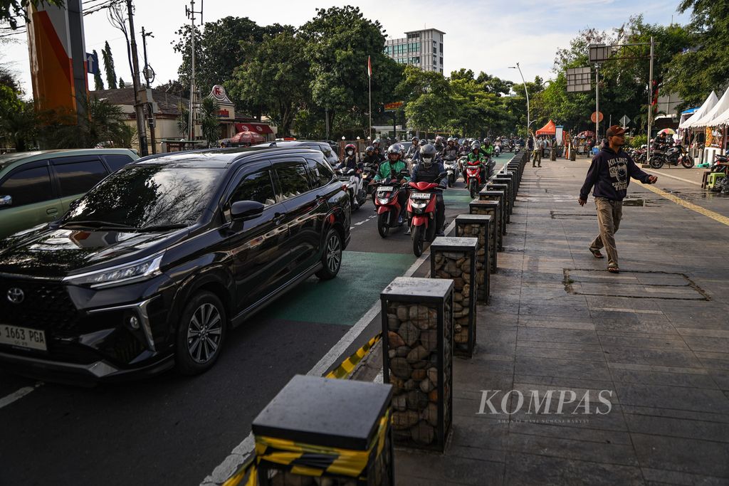 Warga berjalan di atas trotoar di kawasan Cikini, Jakarta, Jumat (1/3/2024). Fasilitas trotoar yang memadai turut mendorong minat warga untuk berjalan kaki dan menggunakan transportasi umum. 