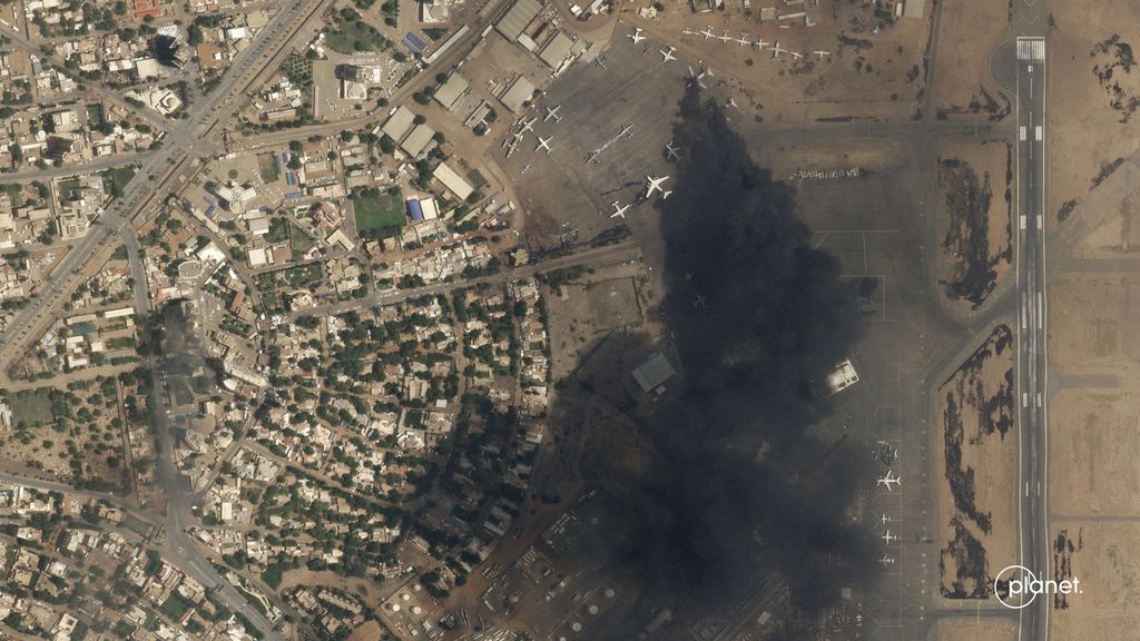 Citra satelit dari Planet Labs PBC menunjukkan ada dua pesawat yang terbakar di Bandara Internasional Khartoum, Minggu (16/4/2023). 