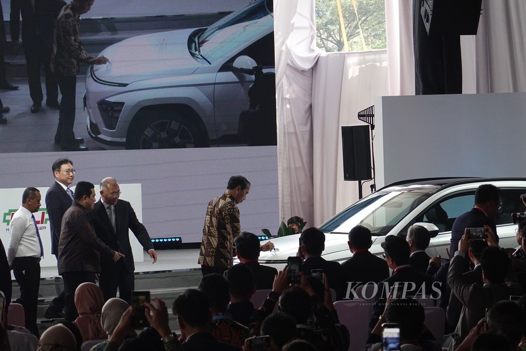 Presiden Joko Widodo membubuhkan tanda tangan di atas mobil Hyundai Kona ketika meresmikan ekosistem kendaraan listrik Indonesia tahun 2024 di PT Hyundai LG Indonesia atau HLI Green Power, Karawang, Jawa Barat, Rabu (3/7/2024). Pabrik tersebut merupakan pabrik sel baterai pertama dan terbesar di Asia Tenggara.