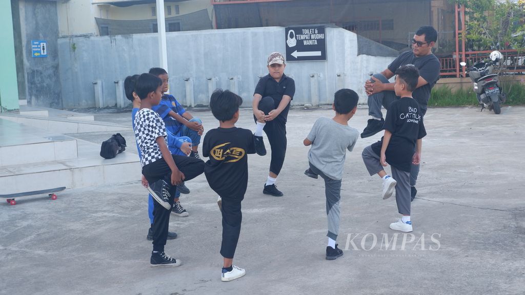 Anak-anak melakukan pemanasan sebelum latihan bermain papan seluncur atau <i>skateboard</i> di halaman Masjid Al-Haq, Kelurahan Banua Anyar, Kecamatan Banjarmasin Timur, Kota Banjarmasin, Kalimantan Selatan, Minggu (11/6/2023).