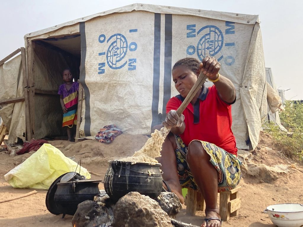 Seorang warga, yang terusir dari kampung halamannya (<i>internally displaced person</i>) di kamp pengungsi Guma IDP, tengah menyiapkan makanan untuk keluarganya di sebuah kamp di Negara Bagian Benue, Nigeria, 6 Januari 2022. 