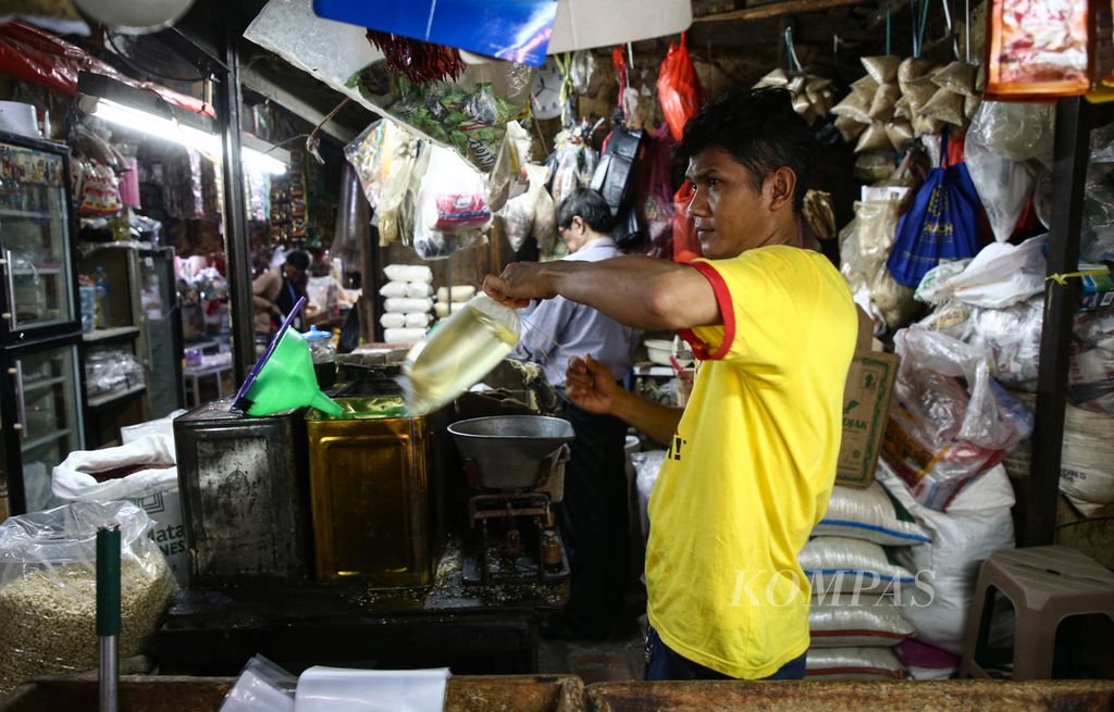 Pekerja mengemas minyak goreng curah di pasar Kebayoran Lama, Jakarta Selatan, Senin (30/1/2022). Minyak goreng curah dijual di pasar tersebut dengan harga Rp 20.000 per kilogram.